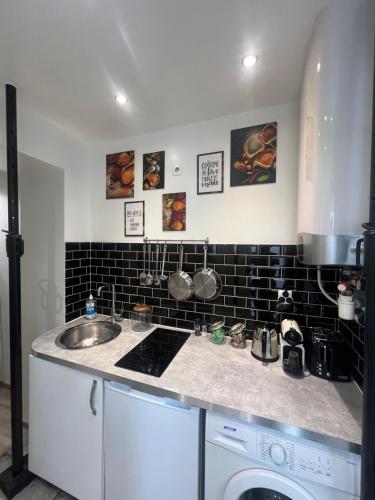 une cuisine avec un évier et un plan de travail dans l'établissement Home Sweet Home Batignolles 1 Bedroom - N37, à Paris