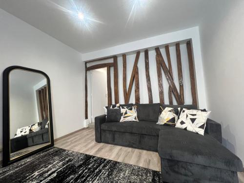 un salon avec un canapé et un grand miroir dans l'établissement Home Sweet Home Batignolles 1 Bedroom - N37, à Paris