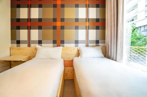 two beds in a room with a window at easyHotel Marseille Euromed in Marseille