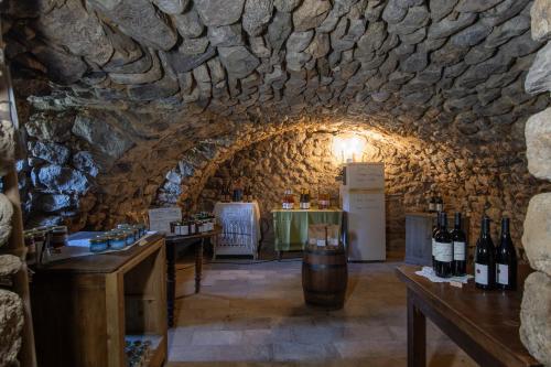 a wine tasting room with a stone wall at La Ferme De Chalas in Valgorge