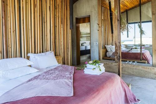 a bedroom with a bed with flowers on it at Areias do Seixo Villas in Santa Cruz