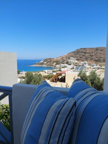 a row of blue pillows on a balcony with the ocean at Kini Bay in Kinion
