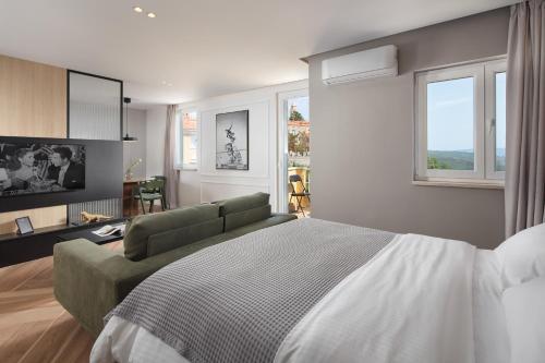 a bedroom with a large bed and a couch at Navona Apartment in Labin