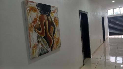 a painting hanging on a wall in a hallway at Tovia Hotel and Suite Limited in Benin City