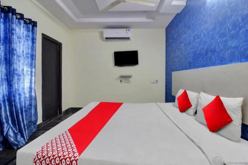 a bedroom with a large bed with red pillows at Hotel O Lavish Stay in Hyderabad