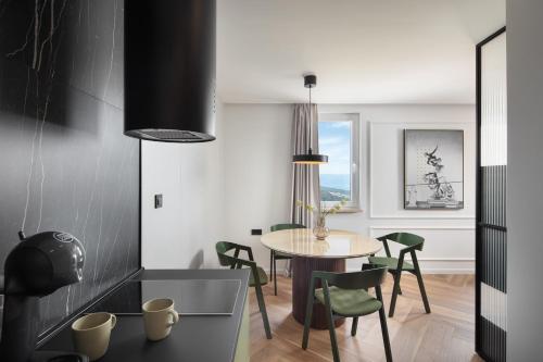 a dining room with a table and green chairs at Navona Apartment in Labin