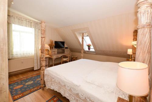 a bedroom with a white bed and a desk at Meerblick in Binz