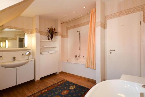 a bathroom with a sink and a bath tub at Meerblick in Binz