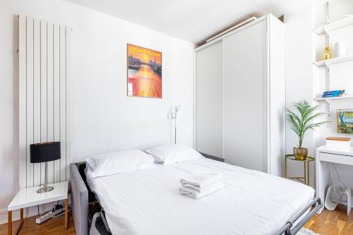 - une chambre blanche avec un lit blanc dans l'établissement GuestReady - Havre de Paix Parisien pour Deux, à Paris