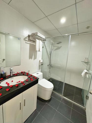 a bathroom with a toilet and a sink and a shower at Sunrise Hanoi Hotel in Hanoi