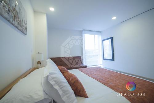a bedroom with a large bed and a window at Apartamento Ópalo 308 in Paipa