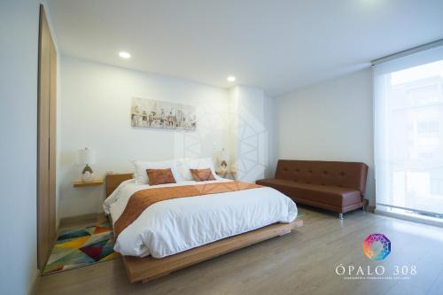 a bedroom with a large bed and a couch at Apartamento Ópalo 308 in Paipa