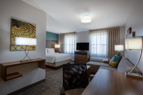 a hotel room with a bed and a couch at Staybridge Suites - Gilbert - East Mesa by IHG in Gilbert