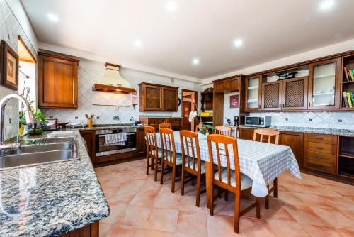 a kitchen with a table and chairs and a sink at AL Monte Lusitano in Loulé