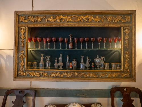 a shelf with a bunch of bottles on it at Quinta de Cypriano - Wine & Nature in Ponte da Barca