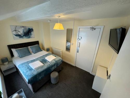 a small bedroom with a bed and a television at North Coast Hotel in Blackpool