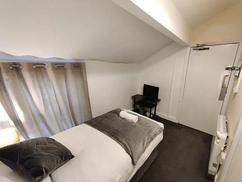 a small bedroom with a bed and a window at North Coast Hotel in Blackpool