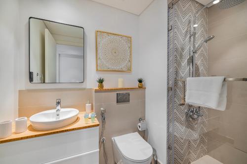 a bathroom with a sink and a mirror and a toilet at Luxury Apt in Dubai Hills Burj Khalifa views in Dubai