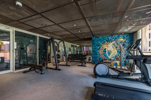 a gym with tread machines and a wall with a mural at Luxury Apt in Dubai Hills Burj Khalifa views in Dubai