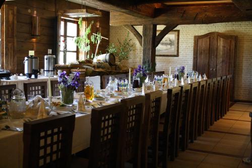 a long table with tables and chairs in a room at Kompleks rekreacyjno- hotelowo-wypoczynkowy FIRLEJOWE SIOŁO in Karolina