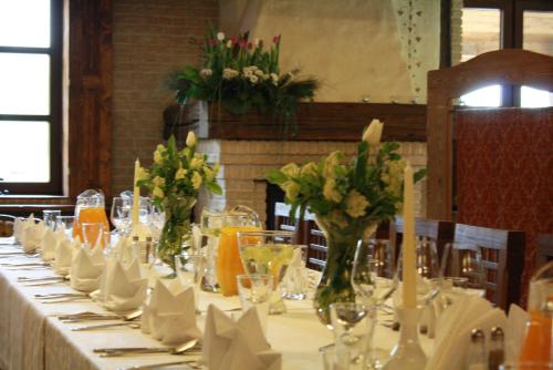 a long table with vases of flowers on it at Kompleks rekreacyjno- hotelowo-wypoczynkowy FIRLEJOWE SIOŁO in Karolina