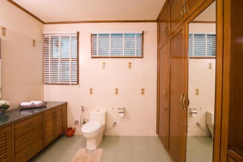 a bathroom with a toilet and a shower at ELIVAAS 3 BHK with Entertainment lounge - The Meadow in Nainital