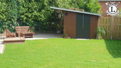 a yard with a bench and a building with a fence at Landhaus Ferien Ostsee in Sterup
