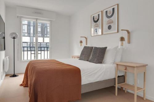 une chambre blanche avec un grand lit et une table dans l'établissement Sublime appartement avec Parking Paris 17 Wagram, à Paris