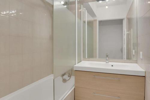une salle de bain avec un lavabo et un miroir dans l'établissement Sublime appartement avec Parking Paris 17 Wagram, à Paris
