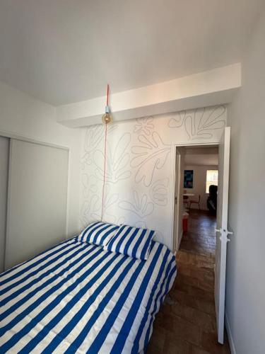 - une chambre avec un lit rayé bleu et blanc dans l'établissement Design T2 Climatisation Coeur Centre Ville Cours MIrabeau, à Aix-en-Provence