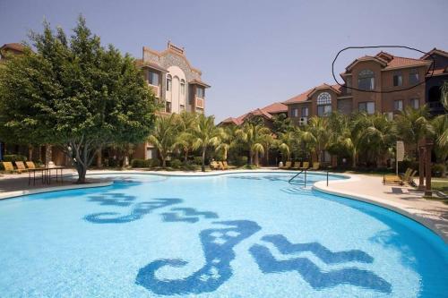 een groot zwembad met palmbomen en gebouwen bij Hermoso Duplex Hotel BUGANVILLAS in Santa Cruz de la Sierra