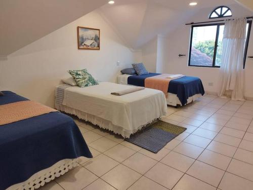 een slaapkamer met twee bedden en een raam bij Hermoso Duplex Hotel BUGANVILLAS in Santa Cruz de la Sierra