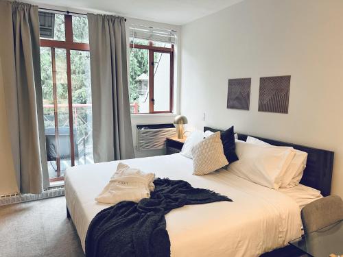 a bedroom with a large white bed and a window at Alpenglow Lodge by Elevate Vacations in Whistler