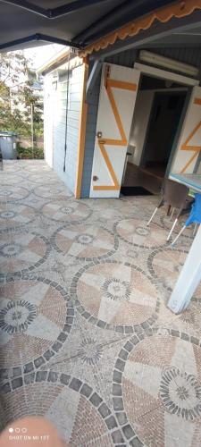 a tiled patio with a table and chairs on a floor at Ti kaz a fredo in Port-Louis