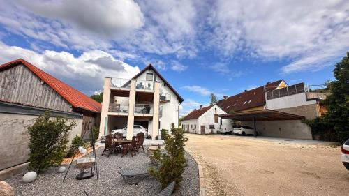 a house with a table and chairs in a driveway at Idyllische Ferienwohnungen in Mossendorf in Burglengenfeld