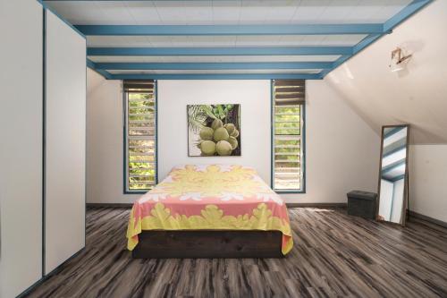 Un dormitorio con una cama y un cuadro en la pared. en Maruapo lodge, en Punaauia
