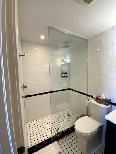 a bathroom with a toilet and a glass shower at Cozy downtown studio getaway in Kingston