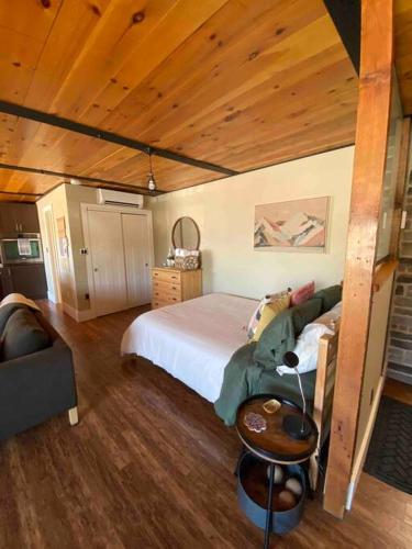 a bedroom with a large bed and a wooden ceiling at Cozy downtown studio getaway in Kingston