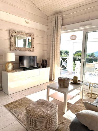 un salon avec une télévision et une table dans l'établissement Jolie Maison Cosy Vue Golfe de Saint Tropez, à Gassin