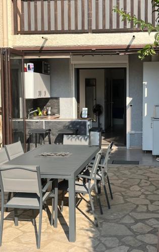 une table et des chaises sur une terrasse avec une cuisine dans l'établissement Calme et confort en rez-de-jardin, à La Londe-les-Maures