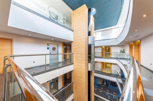 an escalator in a building with a glass ceiling at Hotel Rober Palas in Albir