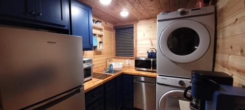 a kitchen with a washing machine and a washer at The Windstorm Cabin - Pet-friendly & a 2-person Jacuzzi hot tub! in Marshall