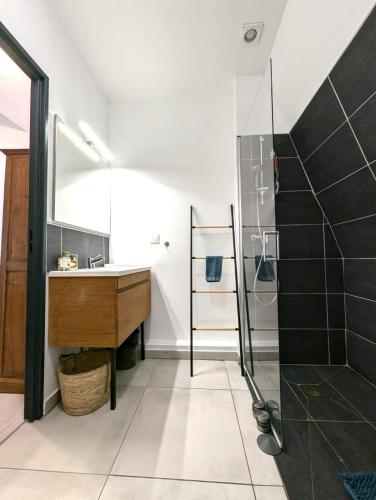 a bathroom with a sink and a glass shower at Le Zanlik - Rare, 100m du Lagon, Hypercentre Saint-Leu in Saint-Leu