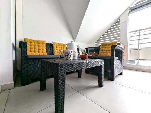 a living room with a table and a couch at Le Zanlik - Rare, 100m du Lagon, Hypercentre Saint-Leu in Saint-Leu