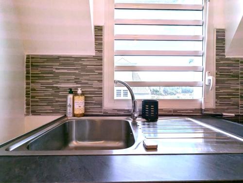 a kitchen sink in a kitchen with a window at Le Zanlik - Rare, 100m du Lagon, Hypercentre Saint-Leu in Saint-Leu