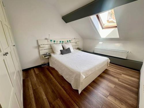 a bedroom with a white bed and a window at Casa curte interioara, centru in Cluj-Napoca