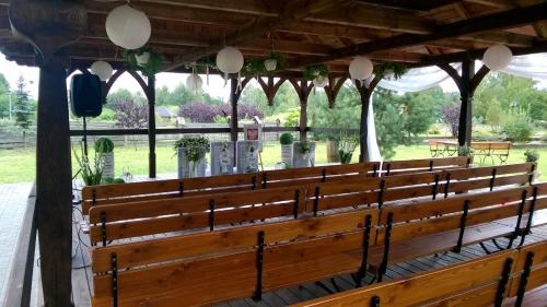 a large wooden bench in a pavilion at Kompleks rekreacyjno- hotelowo-wypoczynkowy FIRLEJOWE SIOŁO in Karolina