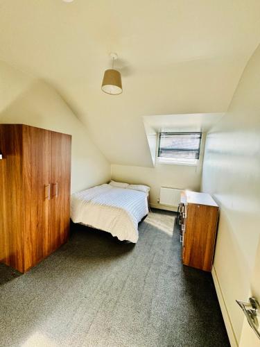 a attic bedroom with a bed and a window at Private room - Shared Bathroom, Wakefield in Wakefield