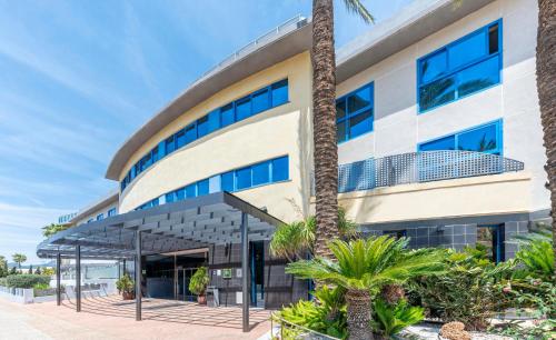 a building with a palm tree in front of it at Hotel Rober Palas in Albir