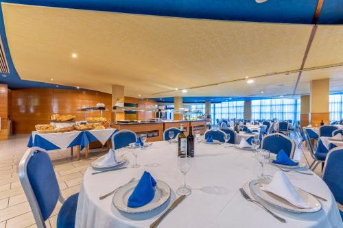 a room with a long table with blue chairs at Hotel Rober Palas in Albir